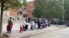 Alrededor de 300 personas acuden a la Plaza San Amaro, en Madrid, para recibir alimentos y productos para los niños. 