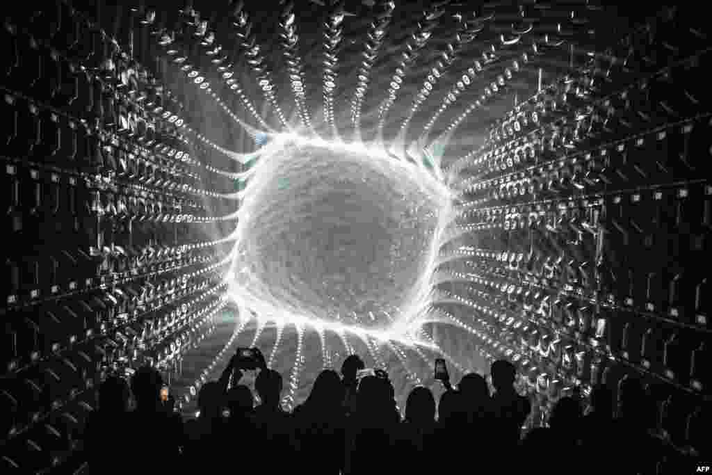 Visitors watch a light display during a tour of the new location for the digital art of Japanese collective "teamLab" at the recently opened 325-metre Azabudai Hills tower in Tokyo.