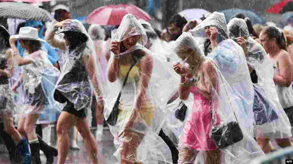 Fans of American singer Taylor Swift shelter from the rain as they arrive for Swift's concert in Sydney.