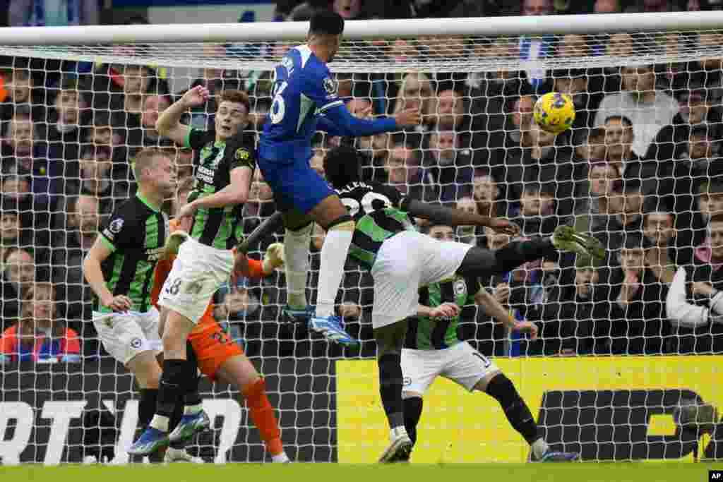 Chelsea's Levi Colwill, top center, scores his side's second goal during the English Premier League soccer match between Chelsea and Brighton and Hove Albion, at Stamford Bridge stadium in London.