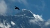 FILE - Seekor burung terbang dengan latar belakang Gunung Everest, terlihat dari Namche Bajar, distrik Solukhumbu, Nepal, 27 Mei 2019. Cheruiyot Kirui, pendaki asal Kenya, ditemukan tewas di dekat puncak gunung tertinggi di dunia.(AP/Niranjan Shrestha)