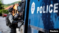 Kosovski policajac ispred zgrade opštine Zvečan, juni 2023.