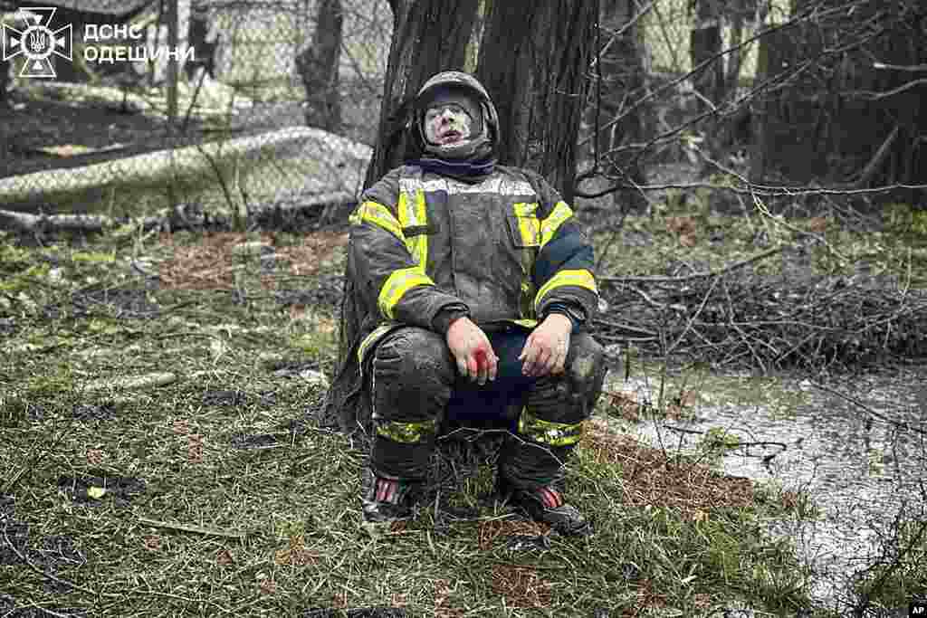 An emergency serviceman sits shocked after a deadly Russian attack in Odesa, Ukraine, in this photo provided by the Ukrainian Emergency Service.