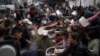 Warga Palestina antre untuk mendapatkan makan di Rafah, Jalur Gaza, 21 Desember 2023. (Foto: AP)