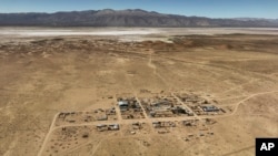 FILE - The town of Tusaquillas, in the northern Argentine province of Jujuy, sits near the Guayatayoc salt lagoon, background, on April 24, 2023. (AP Photo/Victor R. Caivano)