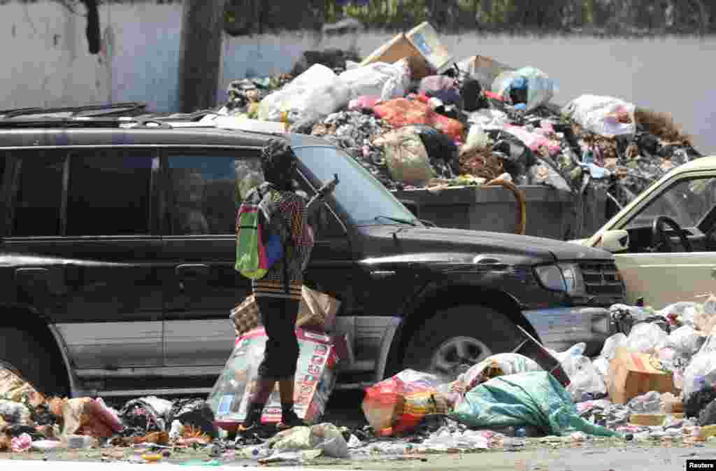 A gang member stands behind a barricade after former police officer Jimmy "Barbecue" Cherizier, and leader of an alliance of armed groups, addressed the media, in Port-au-Prince, Haiti, March 11, 2024.
