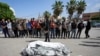 Warga Palestina berdoa di samping jenazah kerabat mereka yang tewas dalam serangan udara Israel di Jalur Gaza, di rumah sakit Al Aqsa di Deir al Balah, Gaza, 4 Mei 2024.(Foto: Abdel Kareem Hana/AP Photo)