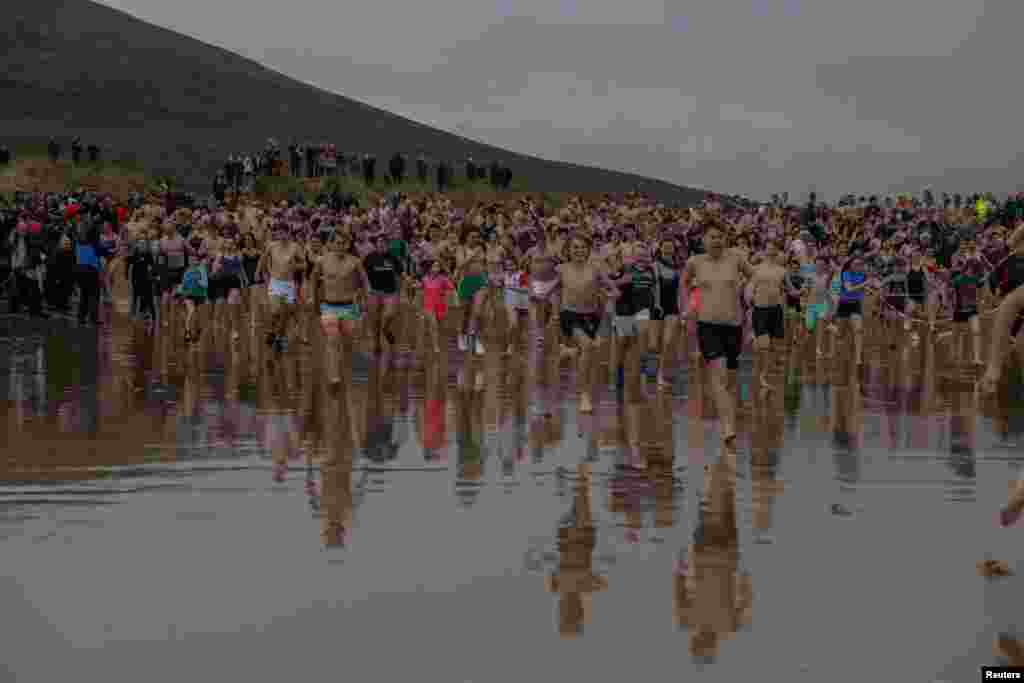 Swimmers make their way into the Atlantic Ocean as part of a New Year's Day charity swim at Dugort Silver Strand Beach on Achill Island, Ireland.