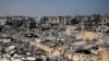 Orang-orang berjalan di antara puing-puing bangunan yang hancur akibat pemboman Israel di Khan Yunis, Jalur Gaza selatan, 16 April 2024. (AFP)
