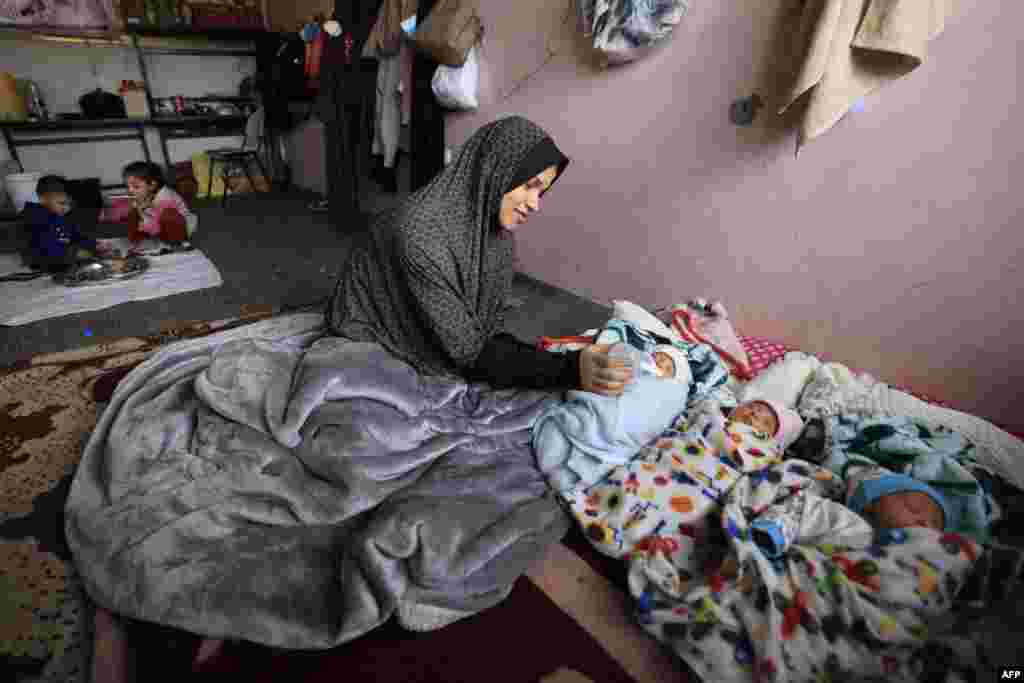 Iman al-Masri, a displaced Palestinian who fled from her home in Beit Hanoun with her family to escape Israeli bombardment, feeds one of her quadruplets — with the fourth still being treated in hospital — as they take shelter at a school in Deir al-Balah in the central Gaza Strip.