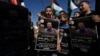 Palestinska djeca mašu zastavom i drže postere na kojima se vidi Khader Adnan, 2. maj 2023.