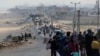 FILE - Warga Palestina, yang mengungsi akibat serangan militer Israel di Gaza selatan, berusaha untuk kembali ke rumah mereka di Gaza utara melalui pos pemeriksaan Israel, seperti yang terlihat dari Jalur Gaza tengah, 15 April 2024.