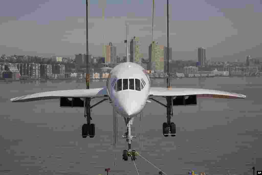 A retired British Airways Concorde supersonic aircraft is lifted by a crane at the Intrepid Museum in New York.