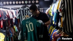 Cassio Brandao holds a shirt worn by Pele in a room filled with jerseys that made him a Guinness World Records holder of the world's largest collection of soccer shirts, in Sao Paulo, Brazil June 24, 2024. (REUTERS/Amanda Perobelli)