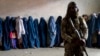 Talibanski borac stoji na straži dok žene čekaju da dobiju obroke hrane koje dijeli grupa humanitarne pomoći, u Kabulu, Afganistan, 23. maja 2023. (AP Photo/Ebrahim Noroozi)