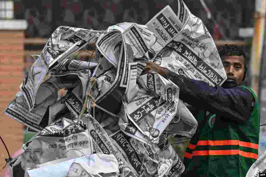 A civic worker dumps election posters in a van a day after the Awami League party led by prime minister Sheikh Hasina won Bangladesh's parliamentary elections, in Dhaka.