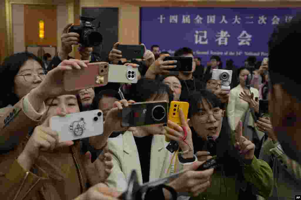 Chinese journalists mob a foreign journalist at the end of the Chinese Foreign Minister's press conference on the sideline of the National People's Congress in Beijing.