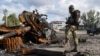 Украинский солдат стоит возле разбитого российского танка в Купянске. Харьковская область. 4 октября 2022 года.