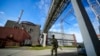 FILE - A Russian serviceman guards in an area of the Zaporizhzhia Nuclear Power Station in territory under Russian military control, southeastern Ukraine, on May 1, 2022. 