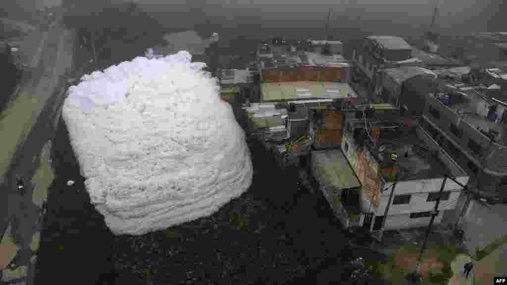 Aerial view shows pungent foam which formed in a polluted river and invaded the Los Puentes neighborhood, in Mosquera, west of Bogota, Colombia.