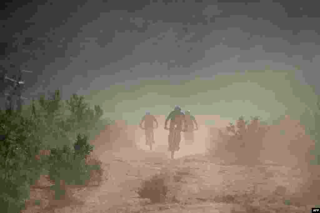 Riders cycle on dusty trails during the first stage of the 2022 Cape Epic mountain bike stage race in the mountains above Somerset West, about 60km from Cape Town, South Africa.