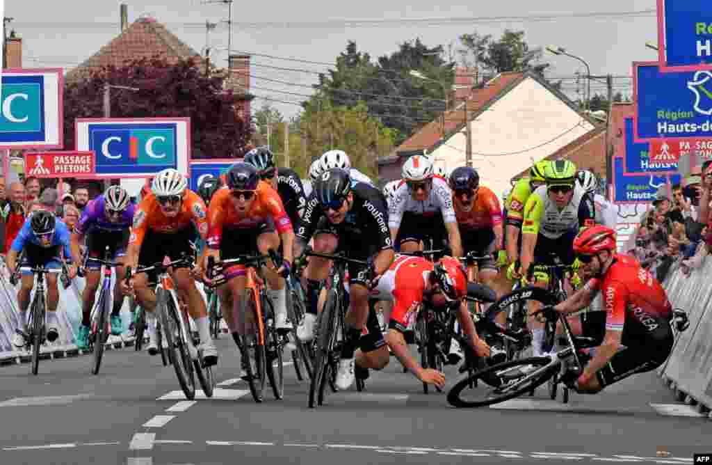 Lotto Soudal's Belgian Arnaud De Lie (2nd-R) and Arkea Samsic's British Daniel McLay (R) crash during the 161 km between Dunkirk and Aniche, first stage of the "4 jours de Dunkerque" (Four days of Dunkirk) cycling race, in Aniche northern France.