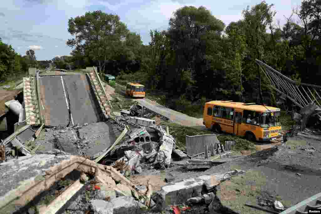 An evacuation convoy travels from Russian troop-occupied Kupiansk town, along a damaged road on the outskirts of Kharkiv, Ukraine, amid Russia's attack on Ukraine, May 30, 2022.