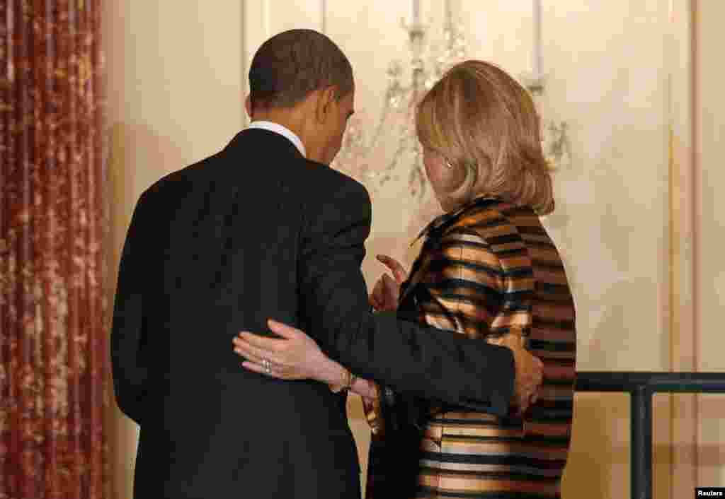 President Barack Obama and Secretary Clinton walk together off stage at a holiday reception for diplomats at the State Department in Washington, December 13, 2010.