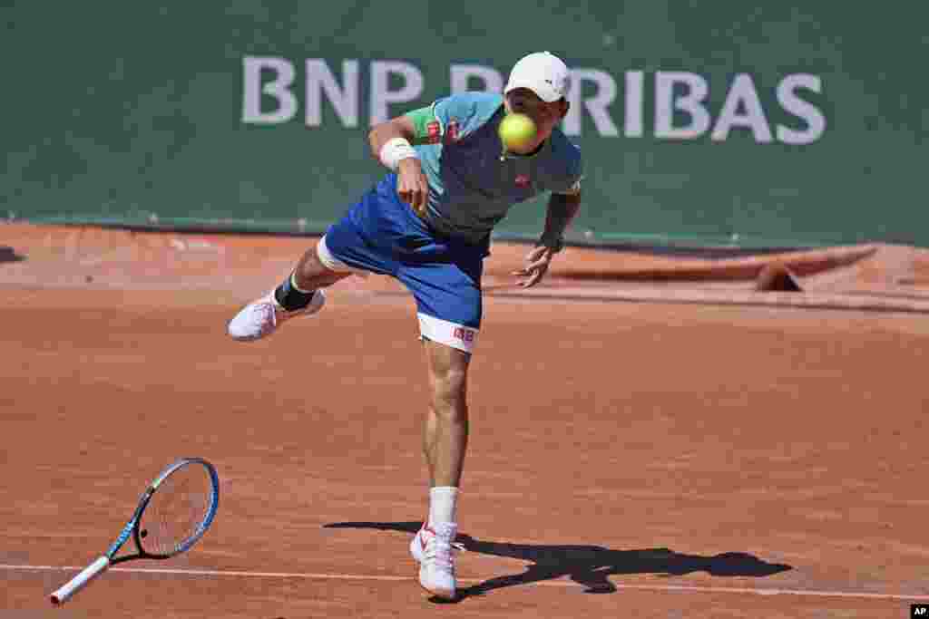 Japan's Kei Nishikori loses his racket as he serves the ball to Italy's Alessandro Giannessi during their first round match of the French Open tennis tournament at the Roland Garros stadium in Paris.