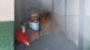 Tras las rejas, la expresidenta interina de Bolivia, Jeanine Áñez, habla con una mujer no identificada en la cárcel de una comisaría en La Paz, el 13 de marzo de 2021. 