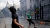 Manifestantes lanzan piedras frente al Congreso en Buenos Aires, Argentina, mientras los legisladores se preparan para ratificar el acuerdo del gobierno con el Fondo Monetario Internacional para refinanciar unos 45.000 millones de dólares en deuda el 10 de marzo de 2022.