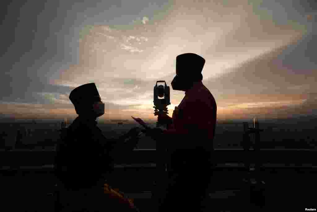 Silhouettes of Malaysia's Islamic Authority's officers and a theodolite which they use to perform "rukyah," the sighting of the new moon which signals the start of the holy month of Ramadan, are seen in Kuala Lumpur, Malaysia.