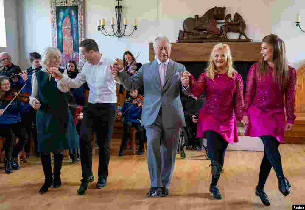 Britain's Prince Charles and Camilla, Duchess of Cornwall, join in with the dancers during their visit at the Bru Boru Cultural Centre in Cashel, County Tipperary, Ireland.