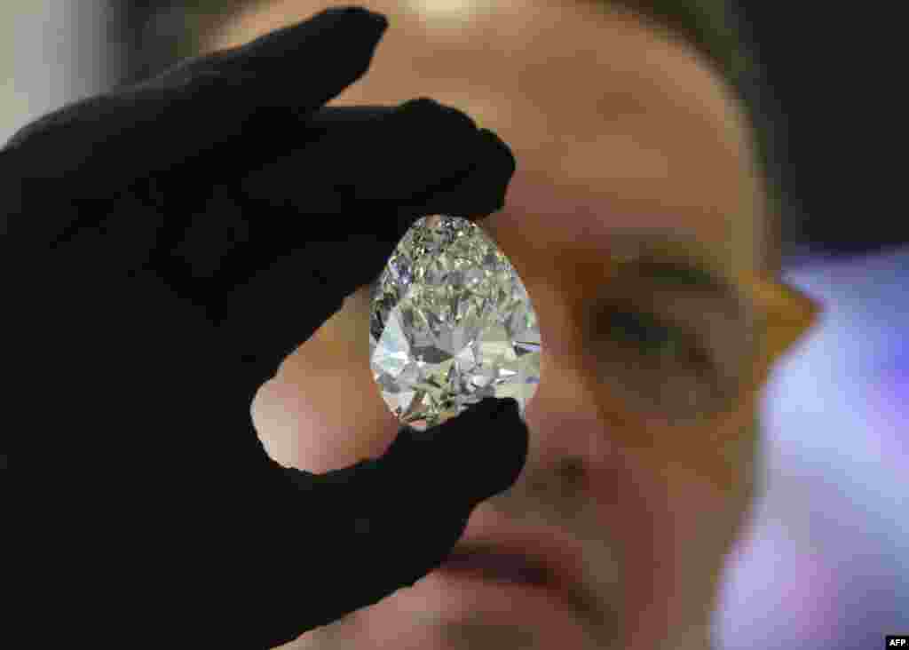 A Christie's auction house staff member displays for the media a giant diamond nicknamed "The Rock," in Dubai, ahead of an auction where it is expected to fetch up to $30 million.