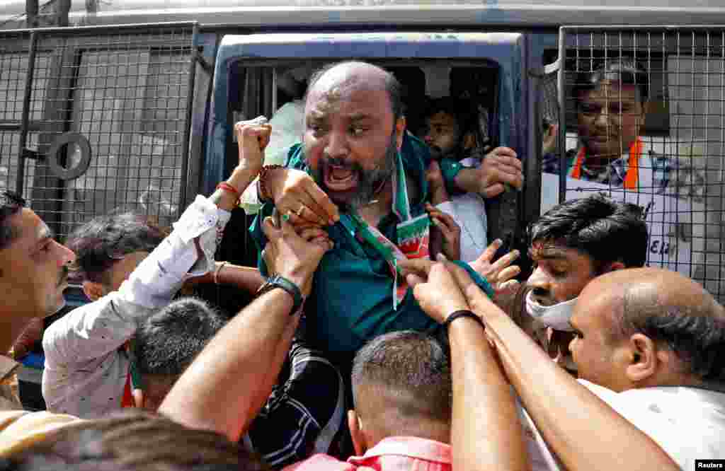 A supporter of India's main opposition Congress party shouts from a police vehicle as he is detained during a protest against the rise in fuel prices, in Ahmedabad, India.