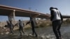 Migrantes cruzan el río Bravo (Grande) hacia la frontera entre México y Estados Unidos, el 19 de diciembre de 2022, en Ciudad Juárez, México. 