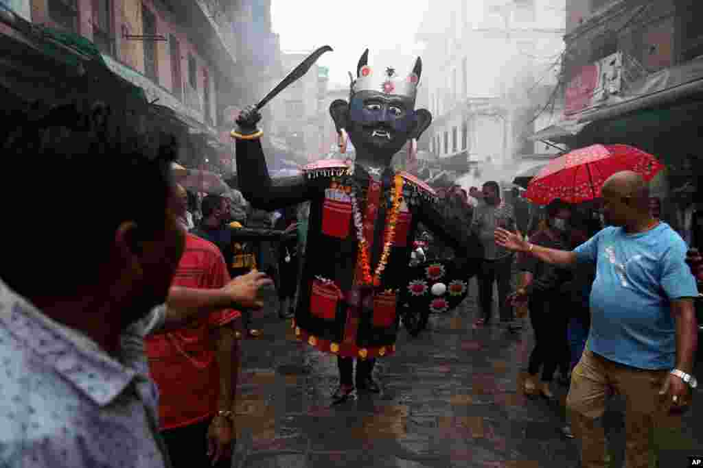 A man walks carrying an effigy of demon Ghantakarna during the Ghantakarna festival in Bhaktapur, Nepal.