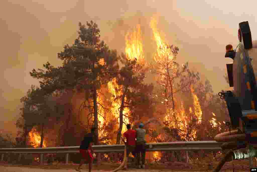 Volunteers help to extinguish a wildfire which broke out in the Datça district of Mugla, Turkey.