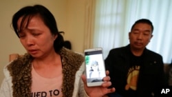 Ronggao Zhang and her husband, Ronggao Zhang, display a photo of them with their missing daughter Yingying Zhang, a University of Illinois student, in Urbana, Illinois, Nov. 1, 2017.