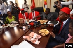 Members of the Ugandan opposition in Parliament address journalists as they return money given to them for consultations on the amendment of the Age Limit Bill, Oct. 25, 2017. (Halima Athumani for VOA)