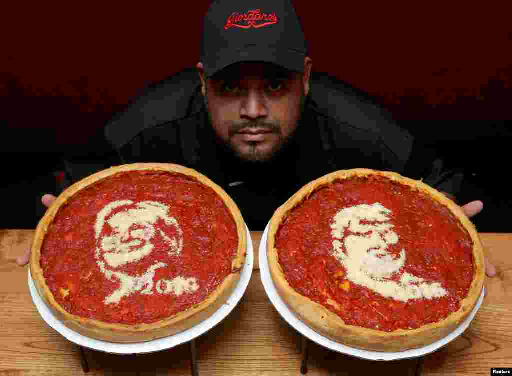 Kepala juru masak, Fabian Martinez, berpose dengan sebuah pizza yang dihiasi gambar kandidat presiden dari Partai Demokrat, Hillary Clinton (kiri) dan kandidat presden Partai Republik, Donald Trump, di Pizzeria Giordano. Chicago, Illinois, 27 September 2016.