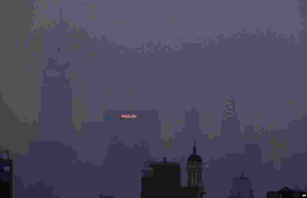 The Met Life and Chrysler buildings glow through a thick haze hanging over Manhattan in New York, July 20, 2021. Wildfires in the American West are creating hazy skies as far away as New York as the massive infernos spew smoke and ash into the air in columns up to six miles high. 