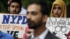 FILE - People hold signs while attending a rally to protest New York Police Department surveillance tactics near police headquarters in New York, Aug. 28, 2013. 