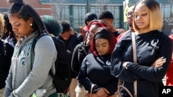 FILE - Peace Warriors from North Lawndale College Prep High School bow their heads during a moment of silence for the victims of gun violence during a Day of Peace rally at Chicago's Legacy Charter School, April 20, 2018.