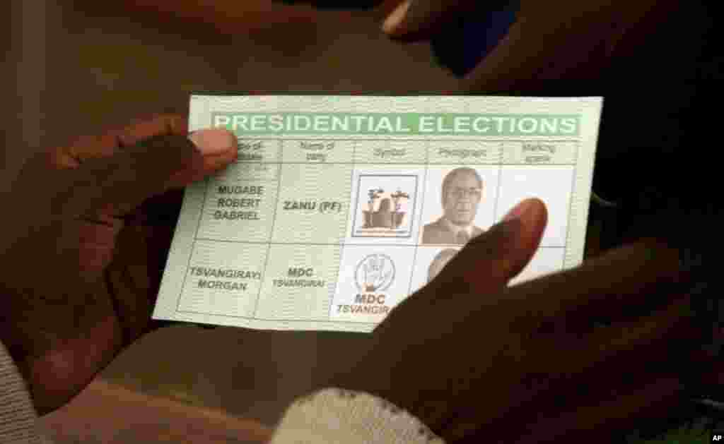 A ballot paper is held as Zimbabweans queue on election day in Harare, Friday, June, 27, 2008. Zimbabwe's one-candidate presidential runoff got off to a slow start, contrasting with the sense of excitement and hope voters had brought to the first round.