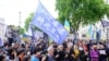 2022年6月4日在伦敦举行的六四事件纪念集会上，來自香港的示威者手持“光复香港，时代革命”的旗帜与支持乌克兰的示威者一起集会。（美国之音/郑乐捷）