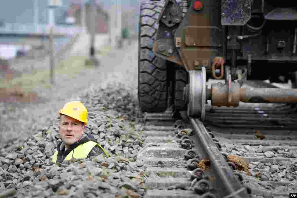 Seorang pekerja memeriksa apa yang akan menjadi ETCS (Rel Kereta Api Eropa yang dikendalikan otomatis) pertama di Profondeville, Wallonia, Belgia. Sistem ETCS memungkinkan secara otomatis untuk menghentikan kereta api yang melaju dengan mengabaikan lampu merah atau melebihi batas kecepatan maksimum yang ditentukan.