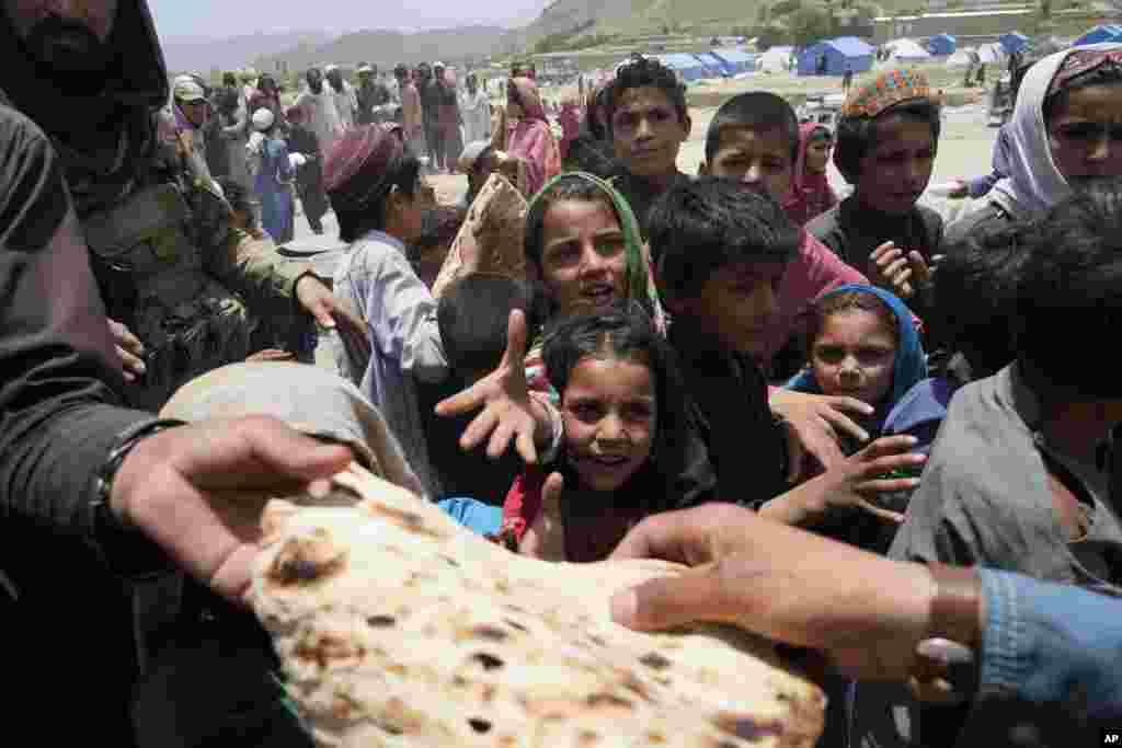 Afghans receive aid at a camp after an earthquake in Gayan district in Paktika province.