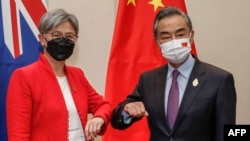 资料：2022年7月8日，在印尼度假胜地巴厘岛努沙杜瓦举行的二十国集团外长会议期间，澳大利亚外交部长黄英贤(左)与中国外交部长王毅碰肘互致问候。(法新社照片)