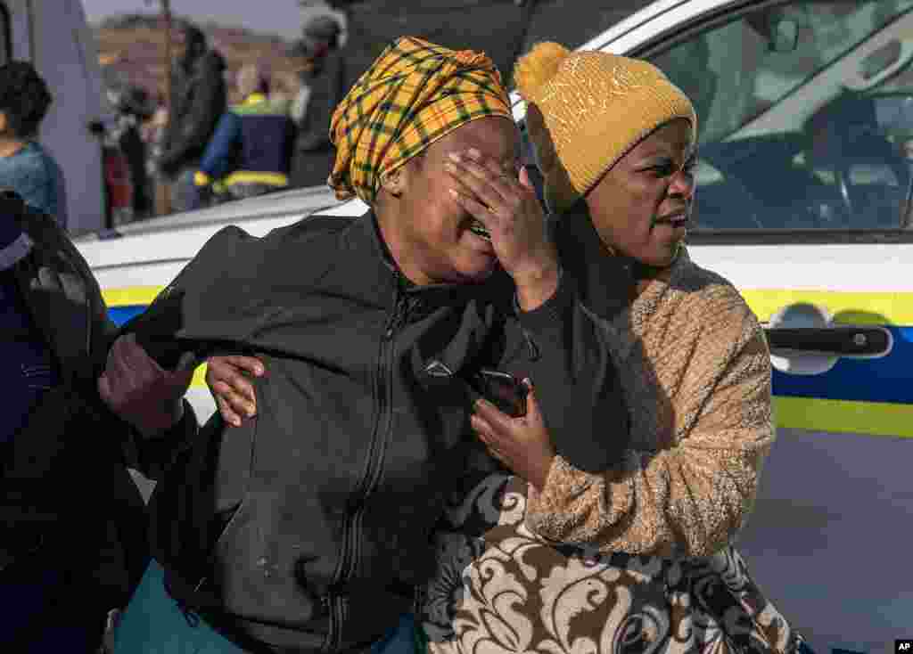 A woman weeps at the scene of an overnight bar shooting in Soweto, South Africa. A mass shooting at a tavern in Johannesburg's Soweto township has killed 15 people and left others in critical condition, according to police. 